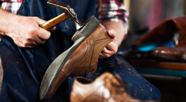 Close up of hands of old shoemaker