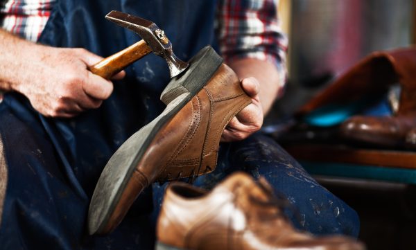 Close up of hands of old shoemaker